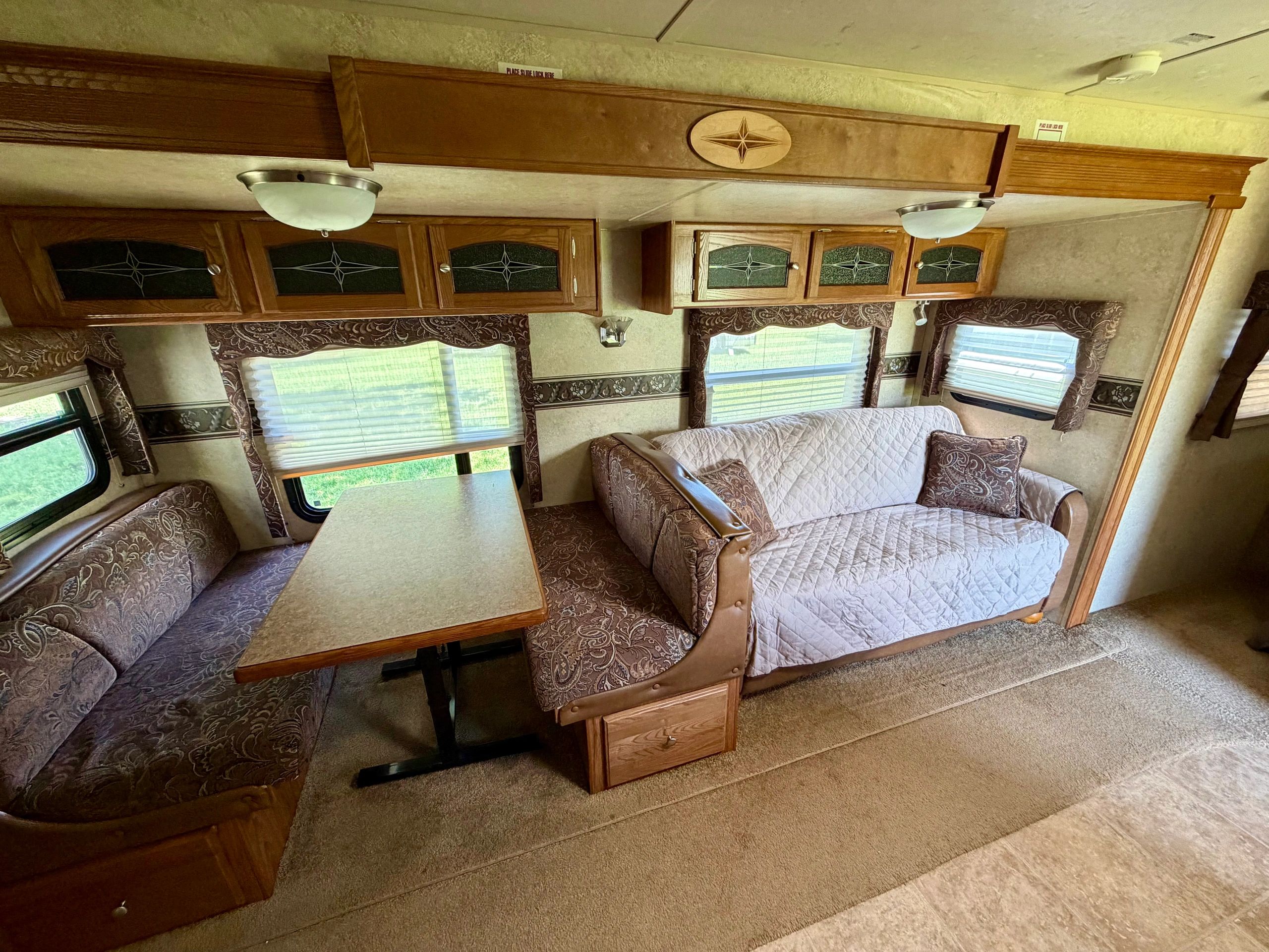 Cozy RV interior with patterned seating and wood cabinetry.