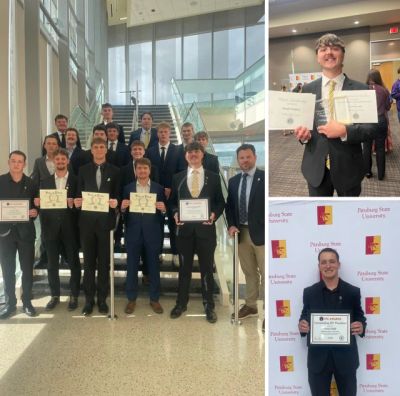 Group of young men holding certificates at an awards event.