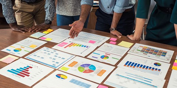 Team analyzing charts and graphs on a table.