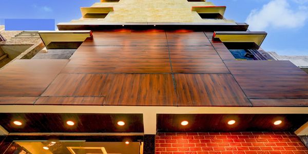 Modern building facade with wood paneling and brick accents under a clear blue sky.