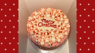 Festive peppermint Christmas cake with red writing.