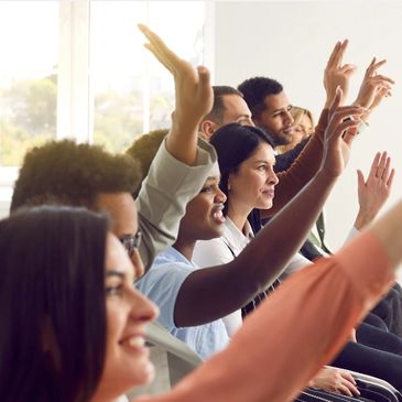 Group of people smiling and raising their hand