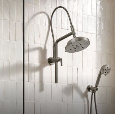 Modern stainless steel shower fixtures mounted on white tiled wall.