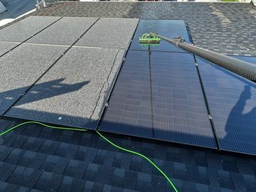 Image of solar panels being cleaned with a water fed pole. Eliminating dirt build up.