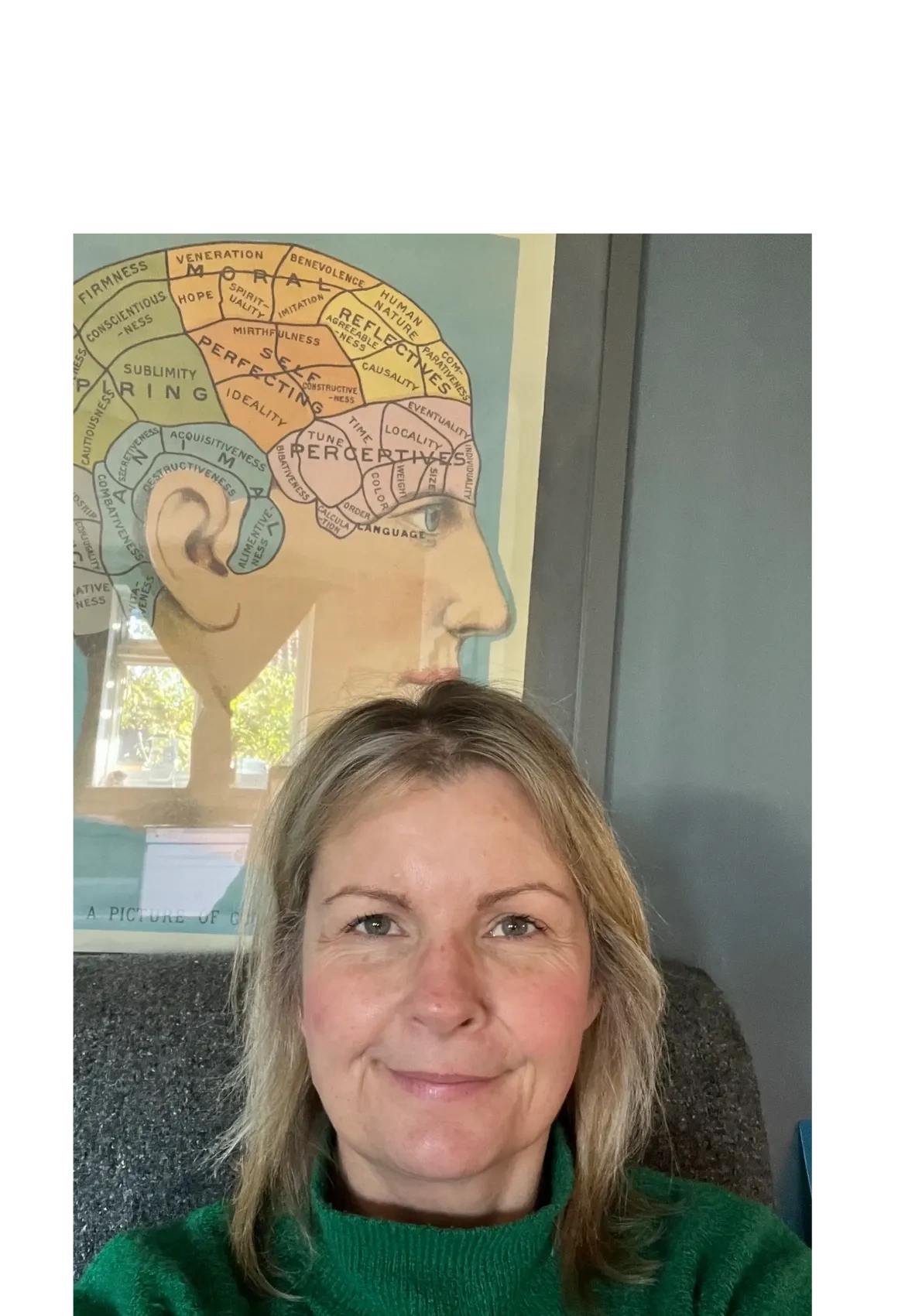 Woman smiling in front of a colorful brain diagram poster. Psychology of the brain. Amanda Jane Morris Counselling