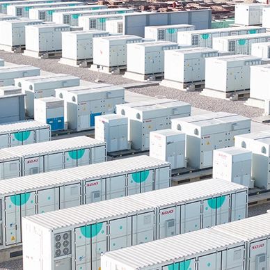 A large array of white industrial battery storage units arranged outdoors.