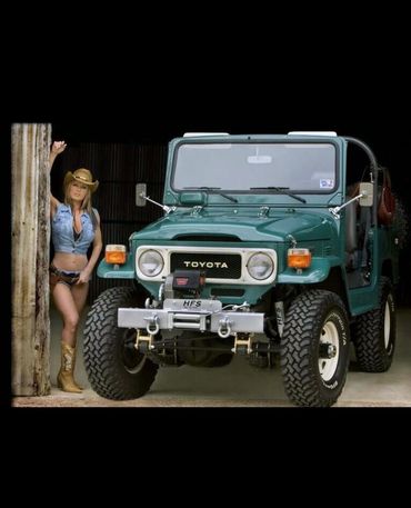 Sunless Tanz airbrush spray tanning model in Katy, TX wearing cowboy boots, crop top, and shorts by a Jeep.