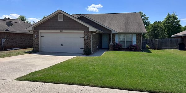 Single-story suburban house with a two-car garage and well-maintained lawn.