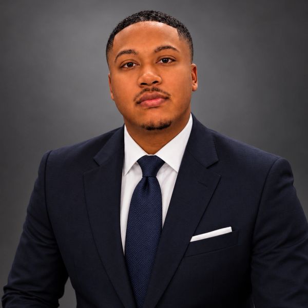 Confident man in a dark suit and tie.