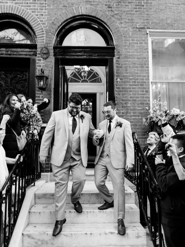 grooms on stairs at Vaux Studio after micro wedding ceremony