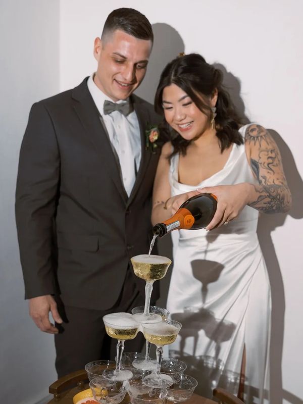 Bride and groom pour champagne after micro wedding ceremony