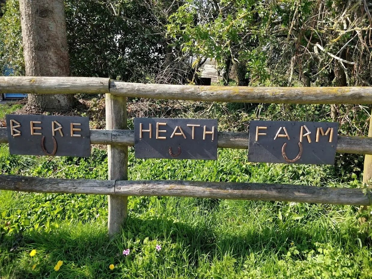 Rustic farm signs on wooden fence with horseshoes.