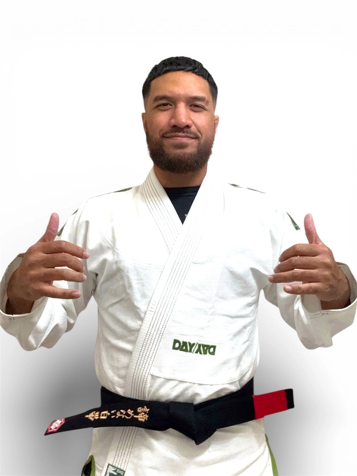 Man smiling in a white martial arts gi with a black belt.
