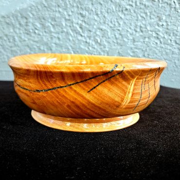 Wooden bowl with natural grain and cracks filled with resin.