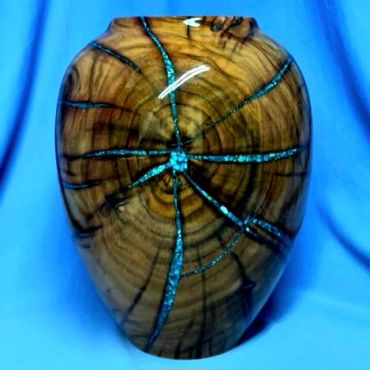 Decorative wooden vase with turquoise inlays.