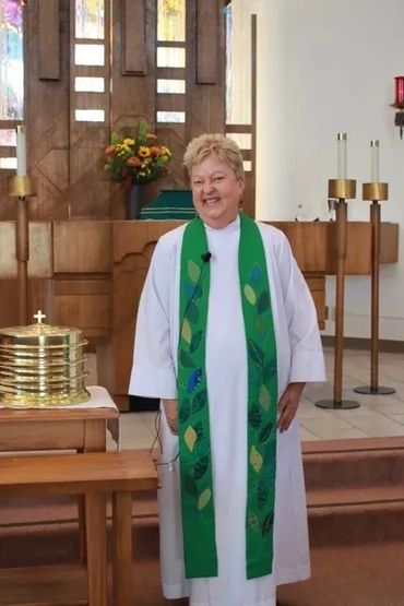 A woman wearing a dress getting photographed in front of the church.