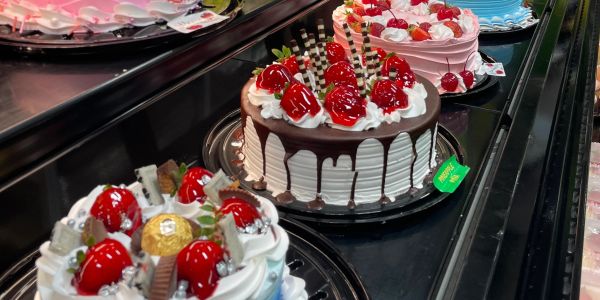 Assorted decorated cakes on display in a bakery.