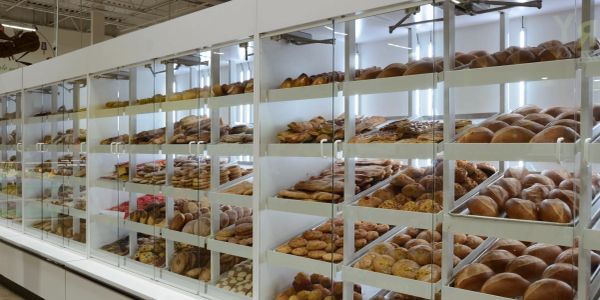Glass bakery display filled with various breads and pastries.