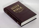 A closed Holy Bible with a maroon cover and gold lettering.