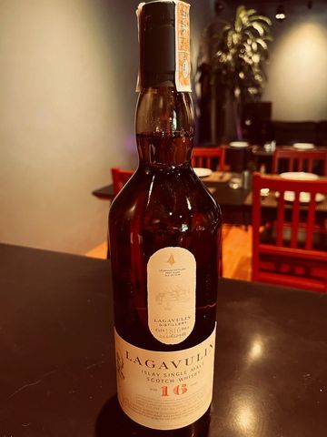 Bottle of Lagavulin 16-year-old single malt Scotch whisky on a table.