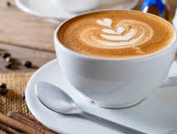 A cup of latte with heart-shaped latte art on top.