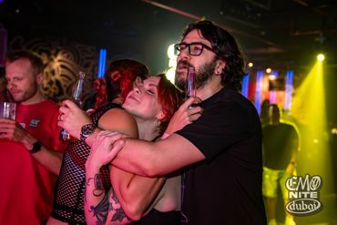 Friends enjoying a night out at a club with vibrant lights and drinks.