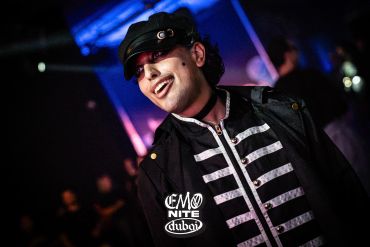 Person smiling in a black outfit at Emo Nite Dubai event.