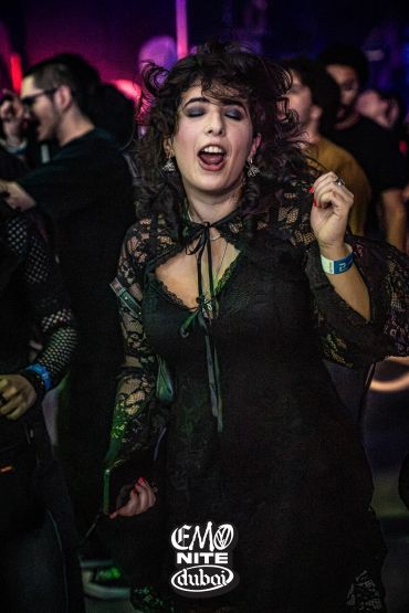 Woman dancing joyfully at Emo Nite Dubai event.
