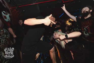 People enjoying an energetic night out at a club with vibrant lighting.