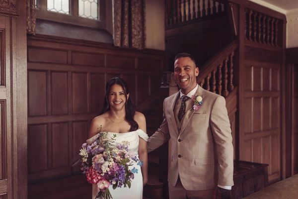 Happy couple in wedding attire indoors.