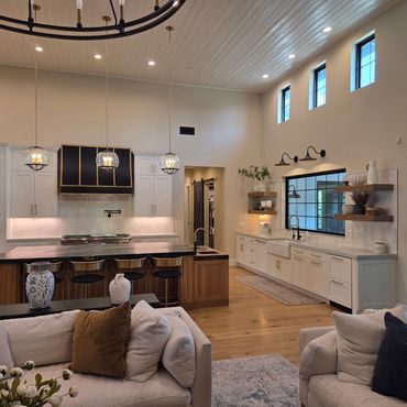 Modern kitchen with island, pendant lights, and cozy seating area.