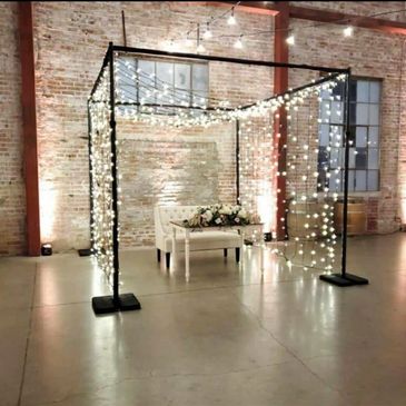 Special Event lights, string lights, draping tent in a wedding venue with brick background.