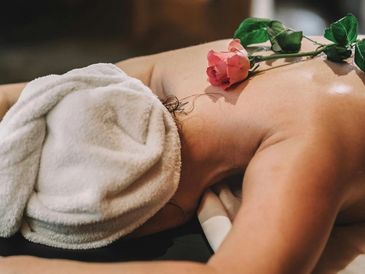 Client indulging in relaxing massage with rise gently placed on her back. 