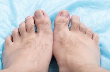 Close-up of feet & toes with visible hair. 