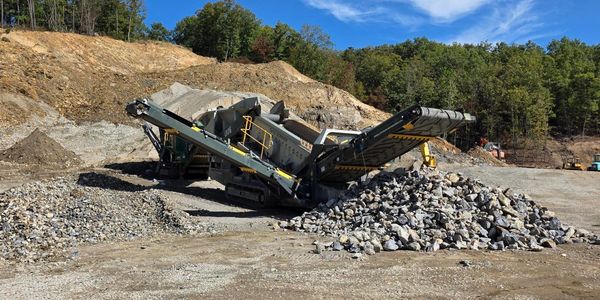 Heavy machinery sorting rocks at a quarry.