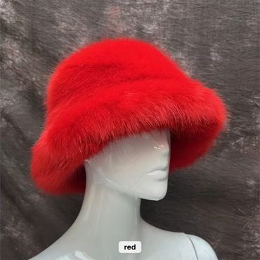Vibrant red furry bucket hat on a white mannequin against a dark backdrop.