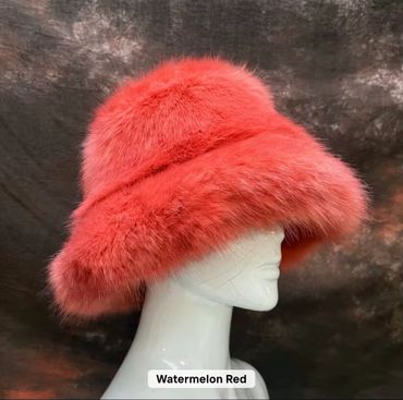 A vibrant watermelon red fluffy hat displayed on a mannequin head.