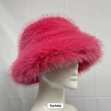 Luxurious fuchsia fur hat displayed on a white mannequin head.