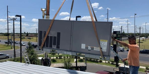Commercial HVAC rooftop unit installation by crane in Mission, TX.