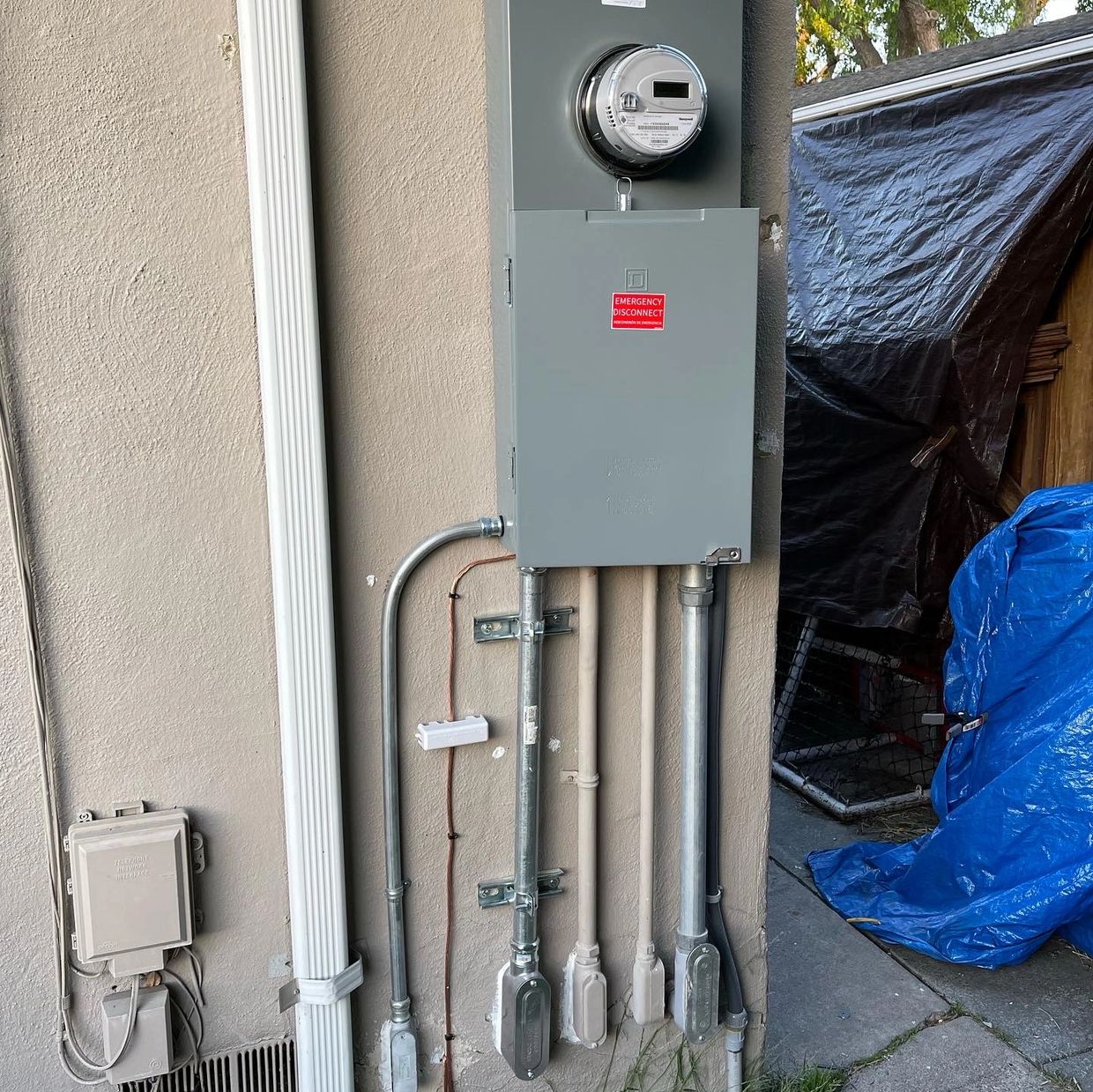 Electric meter and conduit pipes on a wall.