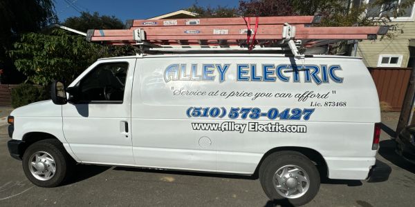 Alley Electric white service van with ladders on top.