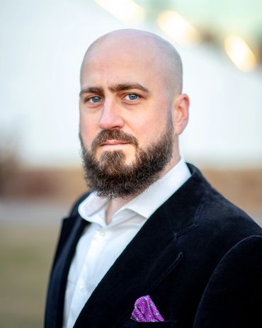 Portrait of a serious bald man with a beard.