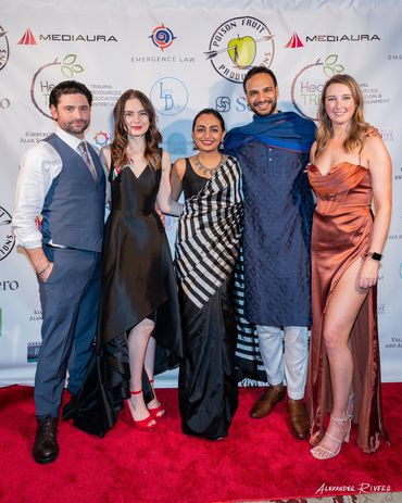 Group of five dressed up on red carpet.