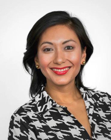 Smiling woman with black and white shirt and red lipstick.