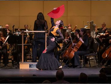 Flamenco dancer performing with live orchestra.