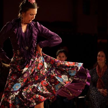 Woman dancing flamenco in colorful dress.