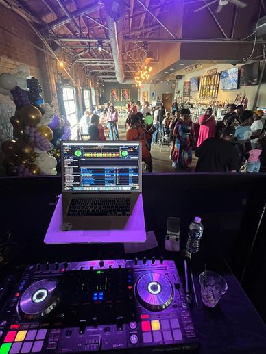 DJ setup overlooking a lively crowd in a stylish indoor venue.