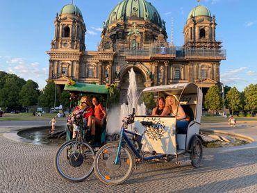Little pop people taking pictures in the tricycle with a background of palace