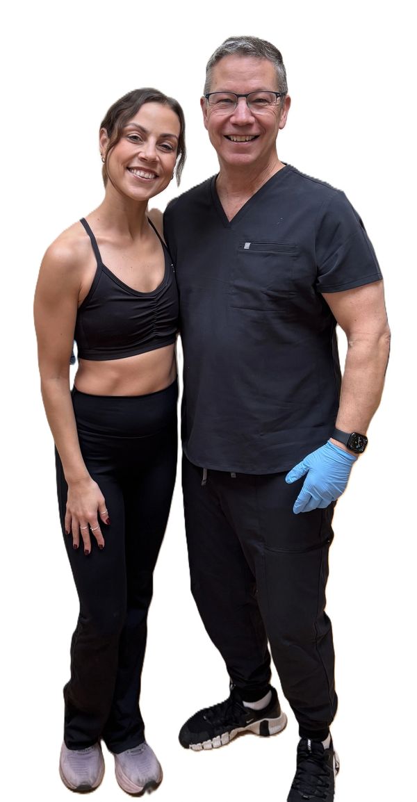 Smiling woman in athletic wear with a man in medical scrubs and gloves.