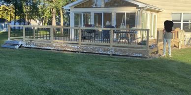 Wooden deck construction in a backyard during sunset.